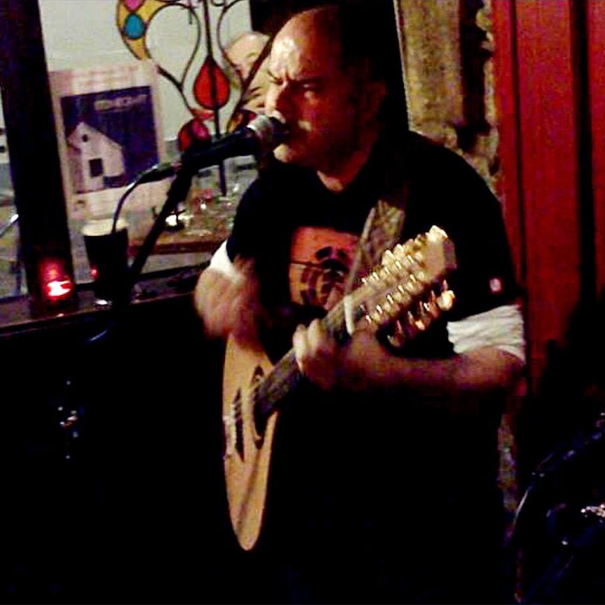 Andy playing his bouzouki and singing live in an Irish pub.